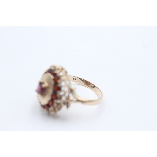 1022 - A 9ct gold garnet oval halo ring - approx. gross weight 4 grams