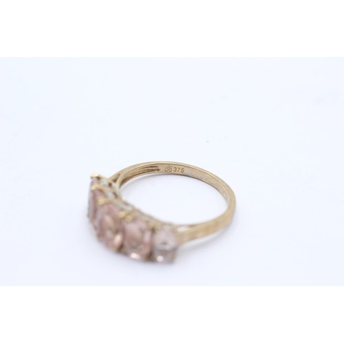 1040 - A 9ct gold morganite five stone ring with diamond accents - approx. gross weight 3.2 grams