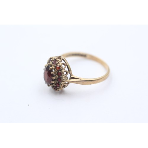 1064 - A 9ct gold garnet halo ring - approx. gross weight 2 grams