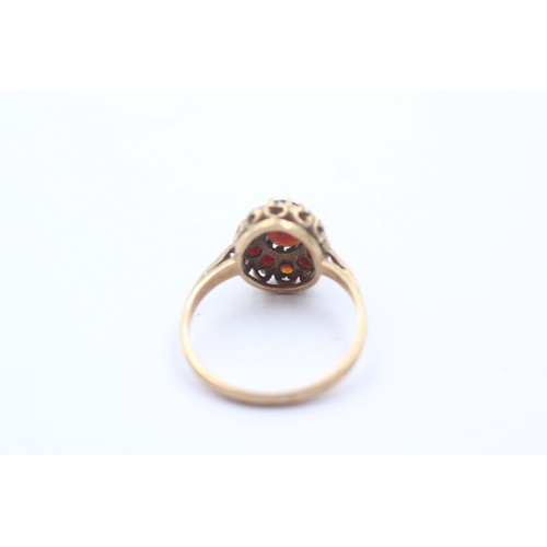 1064 - A 9ct gold garnet halo ring - approx. gross weight 2 grams