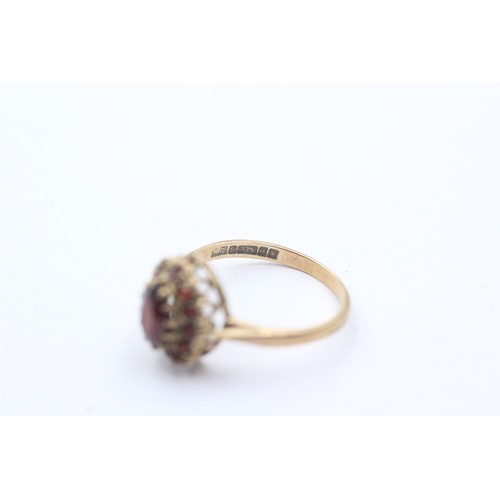 1064 - A 9ct gold garnet halo ring - approx. gross weight 2 grams