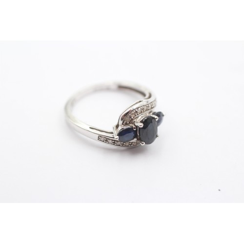 1067 - A 9ct white gold sapphire three stone ring with diamond set shank - approx. gross weight 2.3 grams