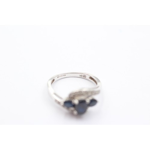 1067 - A 9ct white gold sapphire three stone ring with diamond set shank - approx. gross weight 2.3 grams