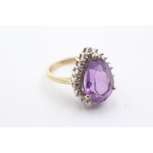 1071 - A 9ct gold amethyst single stone ring with diamond surround - approx. gross weight 4.4 grams