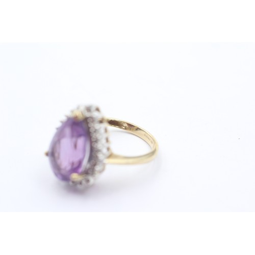 1071 - A 9ct gold amethyst single stone ring with diamond surround - approx. gross weight 4.4 grams