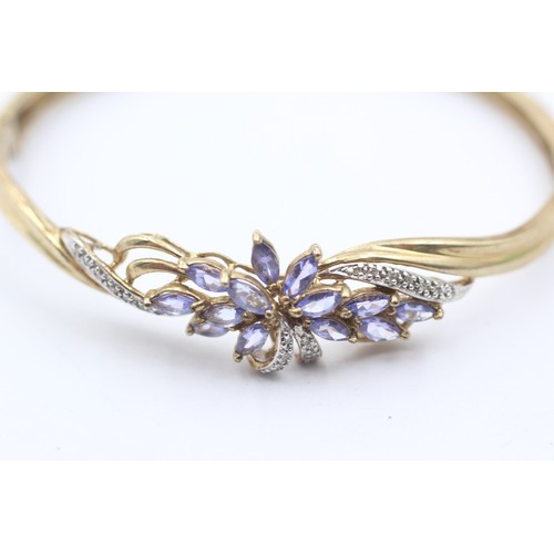 1087 - A 9ct gold diamond and tanzanite hinged bangle - approx. gross weight 11 grams