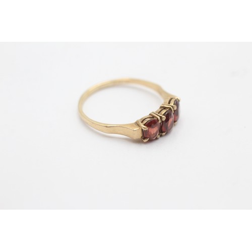 1131 - A 9ct gold garnet three stone ring - approx. gross weight 1.8 grams