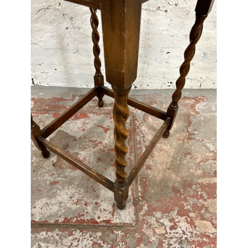 24 - An early 20th century oak serpentine side table on barley twist supports