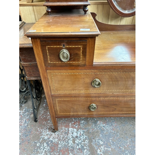 117 - An Edwardian inlaid mahogany dressing table with six drawers, shield shaped mirror and tapering supp... 