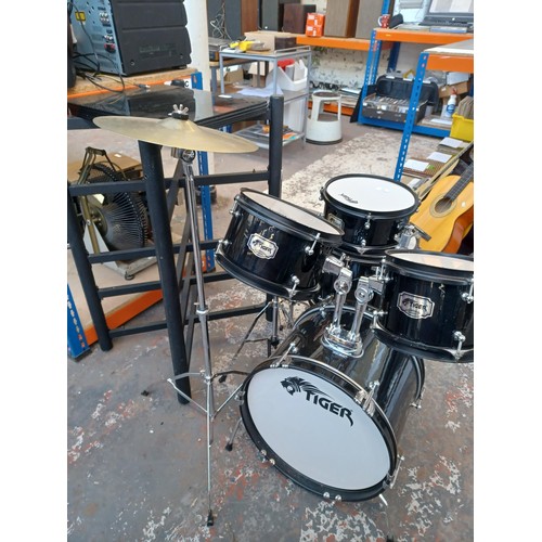 664 - A Tiger child's drum kit comprising bass drum with pedal, floor tom, two rack toms, crash and hi-hat... 