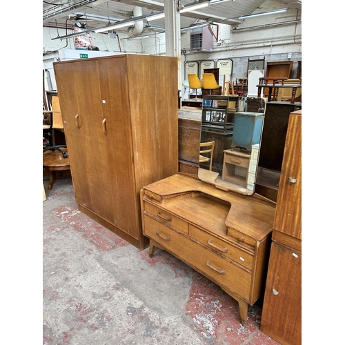 151 - A mid 20th century G Plan oak two piece bedroom suite comprising dressing table and triple wardrobe