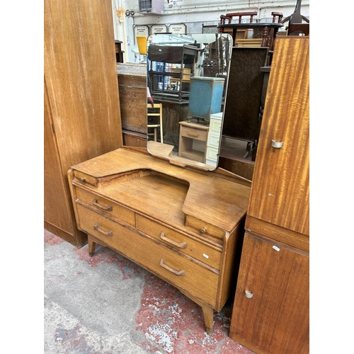 151 - A mid 20th century G Plan oak two piece bedroom suite comprising dressing table and triple wardrobe