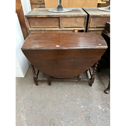 187 - An early 20th century oak drop leaf gate leg dining table on barley twist supports