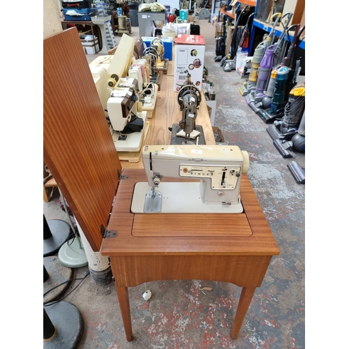 761 - A sewing cabinet containing Singer Zig-Zag model 457 electric sewing machine with foot pedal