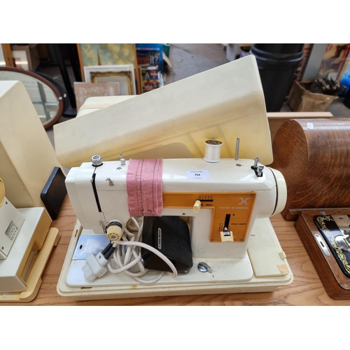 764 - A cased Frister + Rossmann model 45 electric sewing machine with foot pedal and accessories