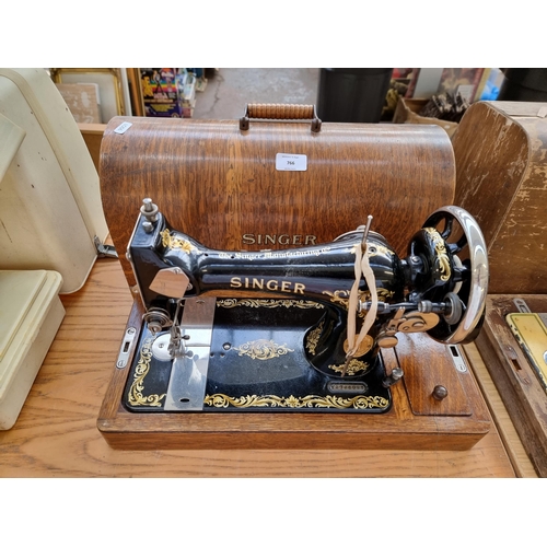 766 - A cased mid 1920s Singer sewing machine with attachments