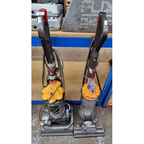 784 - Two Dyson upright bagless vacuum cleaners, one DC33 and one DC40