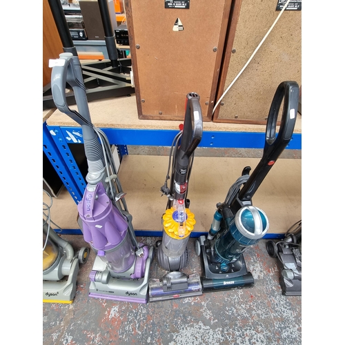 785 - Three upright bagless vacuum cleaners, one Dyson DC07, one Dyson DC40 and one Hoover