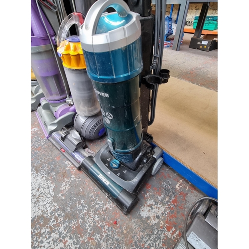 785 - Three upright bagless vacuum cleaners, one Dyson DC07, one Dyson DC40 and one Hoover