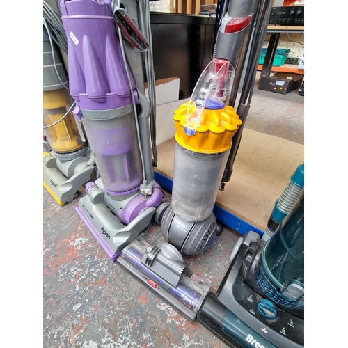 785 - Three upright bagless vacuum cleaners, one Dyson DC07, one Dyson DC40 and one Hoover