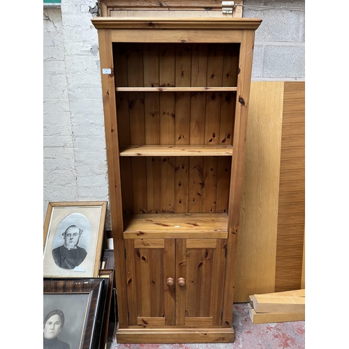 16 - A modern pine three tier open bookcase with two lower cupboard doors