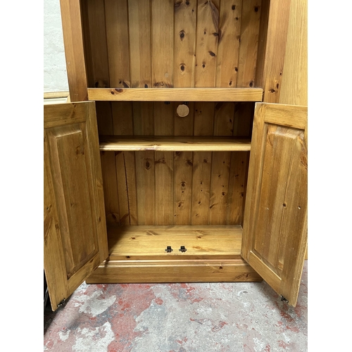 16 - A modern pine three tier open bookcase with two lower cupboard doors