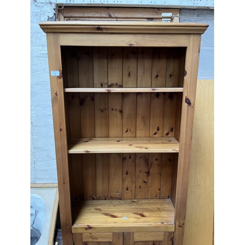 16 - A modern pine three tier open bookcase with two lower cupboard doors