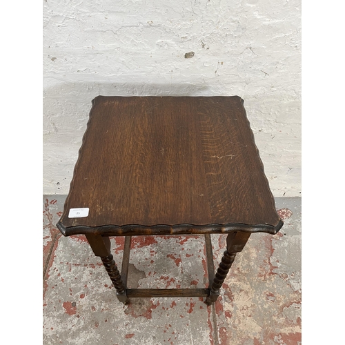 25 - An early 20th century oak pie crust edge side table on barley twist supports