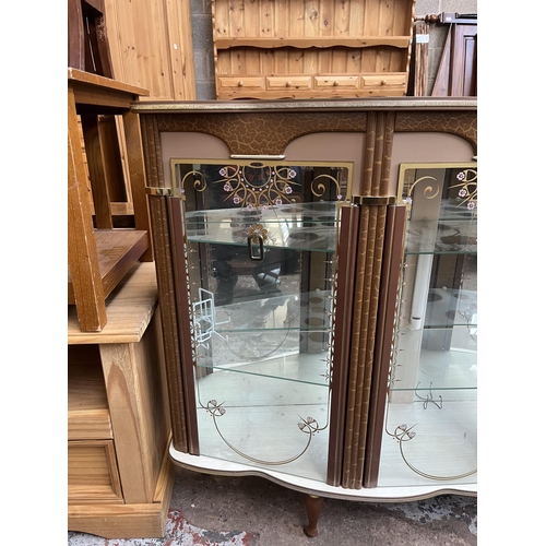 39 - A mid 20th century Kitsch teak effect and glass display cabinet with two doors, mirror back and two ... 