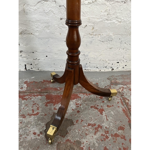 43 - A Regency style mahogany jardinière stand with tripod pedestal support, brass castors and circular t... 