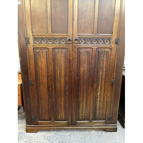 47 - A Crown Ay carved oak double wardrobe with linenfold panel doors