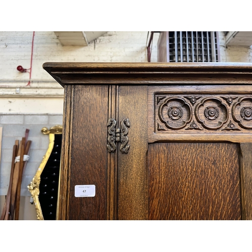 47 - A Crown Ay carved oak double wardrobe with linenfold panel doors