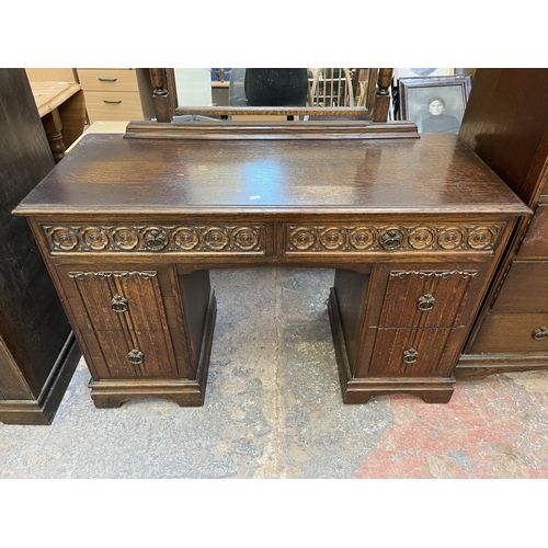 48 - A Crown Ay carved oak dressing table with four linenfold drawers and two upper drawers