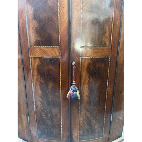 56 - A Georgian inlaid mahogany bow front wall mountable corner cabinet