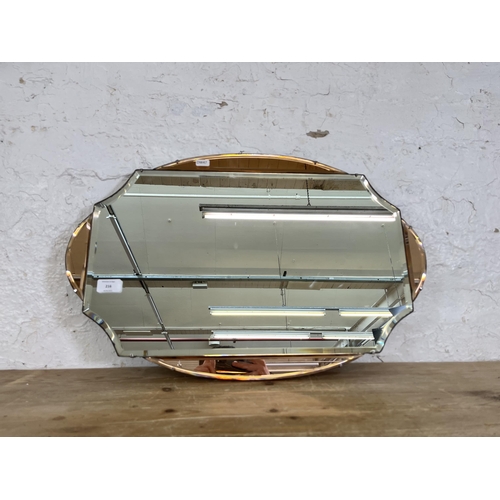 216 - A vintage Art Deco style frameless bevelled edge wall mirror with rose gold tinted decoration - appr... 