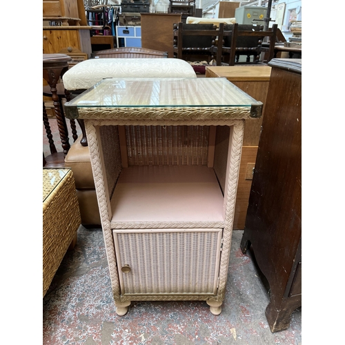 105 - A Lloyd Loom Lusty pink painted wicker and glass top bedside cabinet