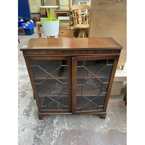 110 - A Georgian style mahogany astral glazed two door bookcase with bracket supports