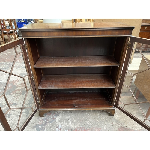 110 - A Georgian style mahogany astral glazed two door bookcase with bracket supports