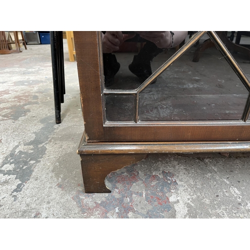 110 - A Georgian style mahogany astral glazed two door bookcase with bracket supports