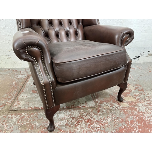 132 - A brown leather Chesterfield wing back armchair