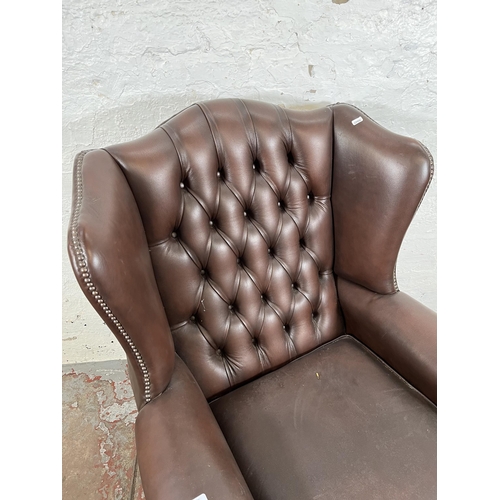 132 - A brown leather Chesterfield wing back armchair