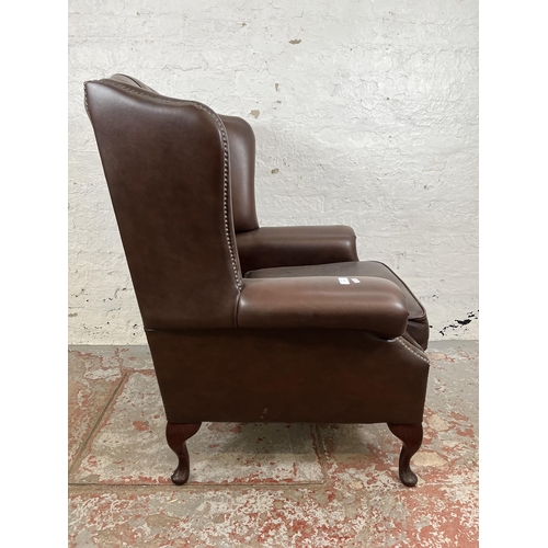 132 - A brown leather Chesterfield wing back armchair