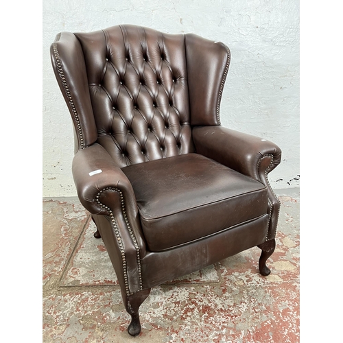 133 - A brown leather Chesterfield wing back armchair