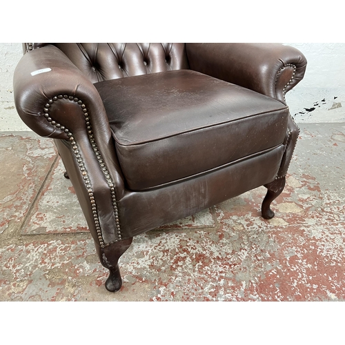 133 - A brown leather Chesterfield wing back armchair