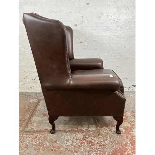 133 - A brown leather Chesterfield wing back armchair