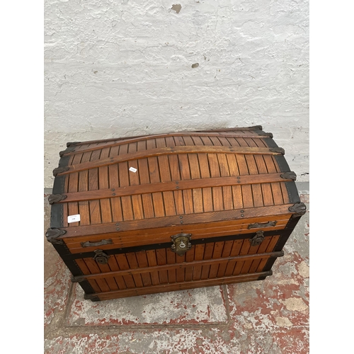 138 - A vintage wooden dome top travel trunk with fitted interior