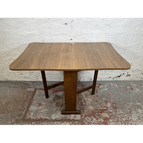 142 - A mid 20th century oak effect drop leaf gate leg dining table