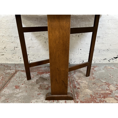 142 - A mid 20th century oak effect drop leaf gate leg dining table