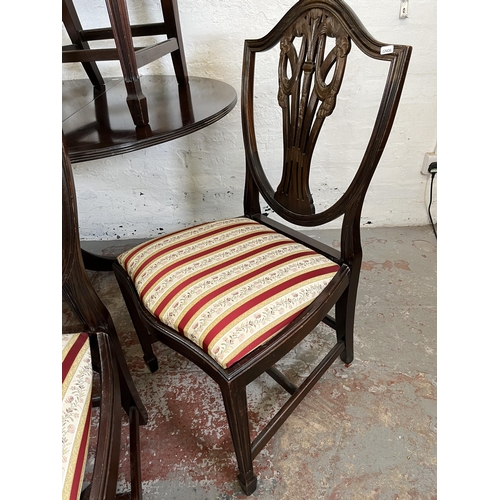 152 - A Georgian style mahogany drop leaf oval dining table and six Hepplewhite style dining chairs