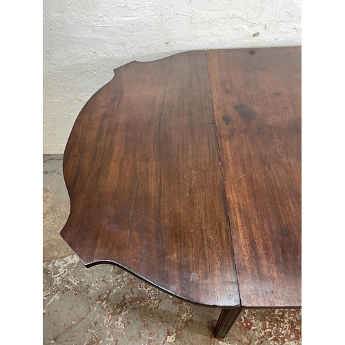 157 - A George II mahogany drop leaf gate leg serpentine dining table